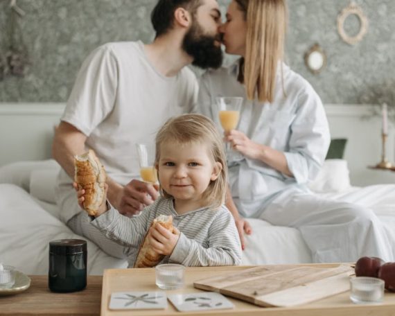 Family enjoying breakfast in bed, expressing love and togetherness.